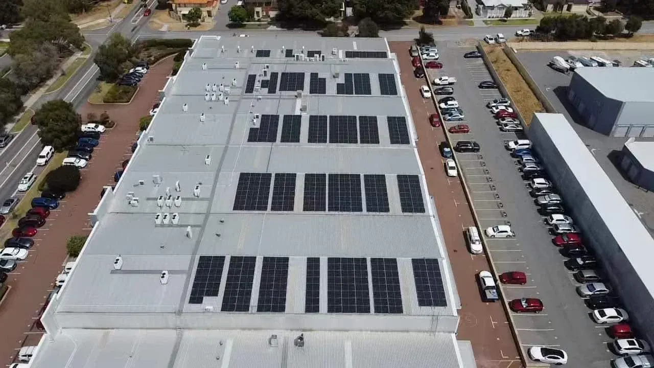 Aerial view of commercial rooftop solar arrays on an industrial building